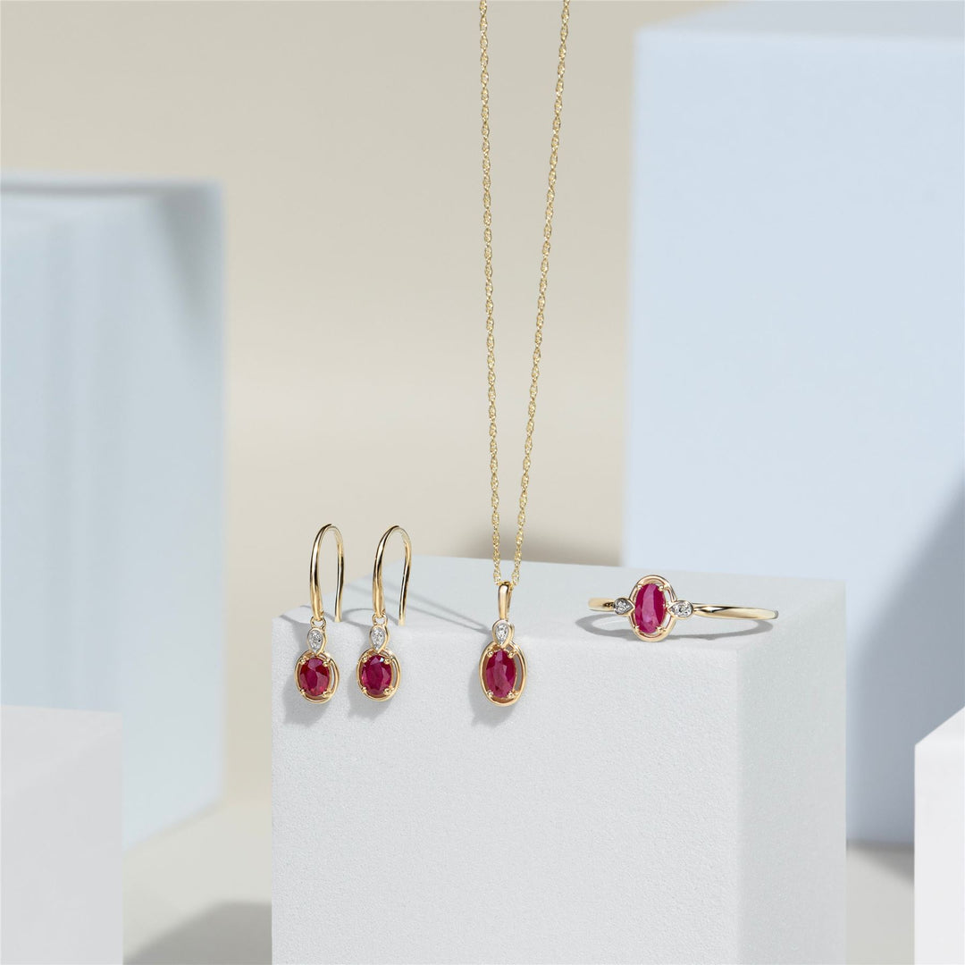 Pendientes colgantes clásicos de rubí ovalado y diamante redondo en oro amarillo de 9 quilates