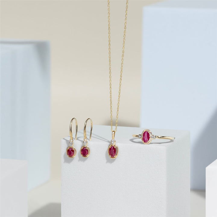 Pendientes colgantes clásicos de rubí ovalado y diamante redondo en oro amarillo de 9 quilates