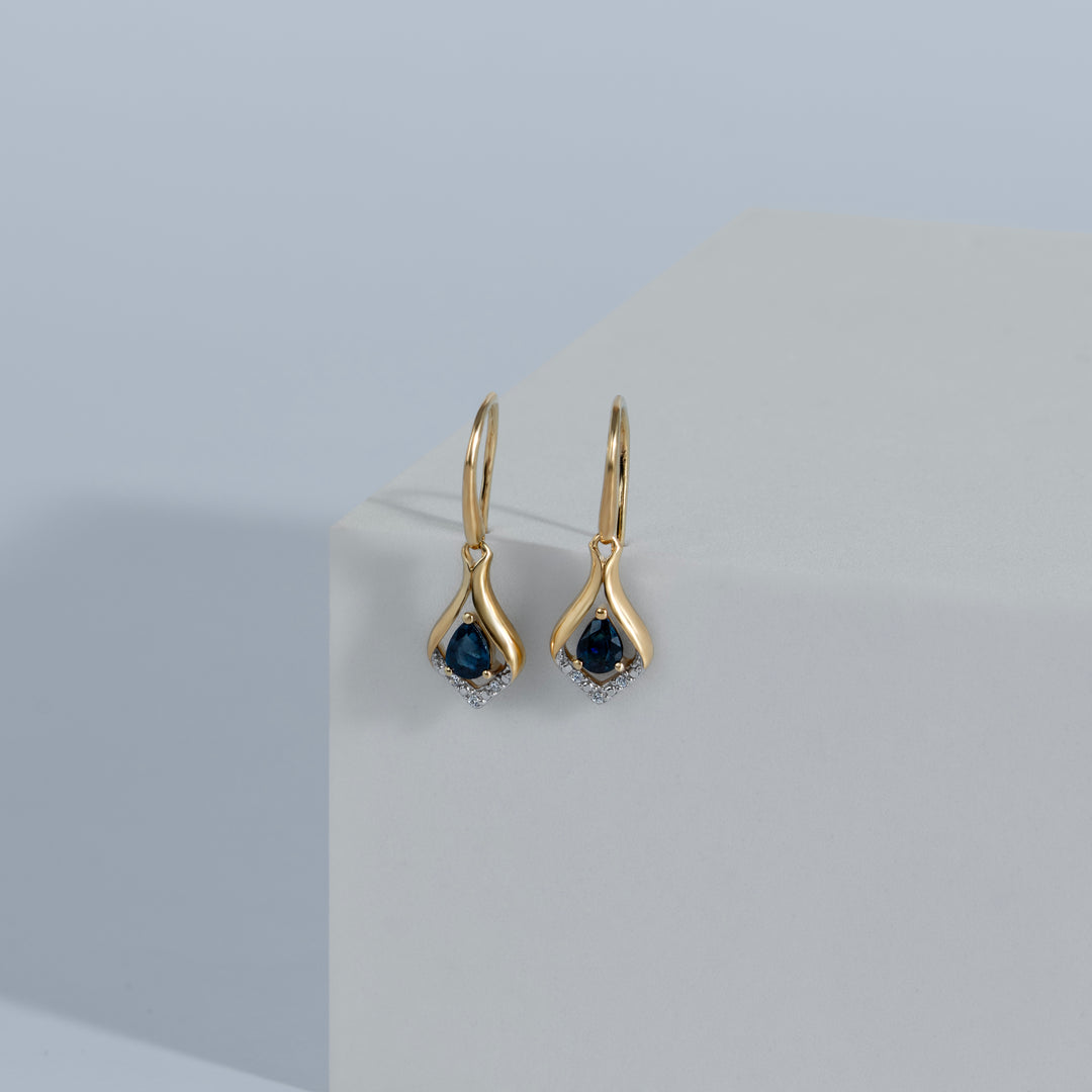 Aretes colgantes clásicos con zafiro pera y halo de hojas de diamantes en oro amarillo de 9 quilates
