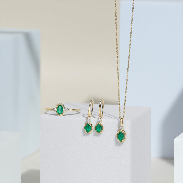 Pendientes colgantes clásicos de esmeralda ovalada y diamantes redondos en oro amarillo de 9 quilates