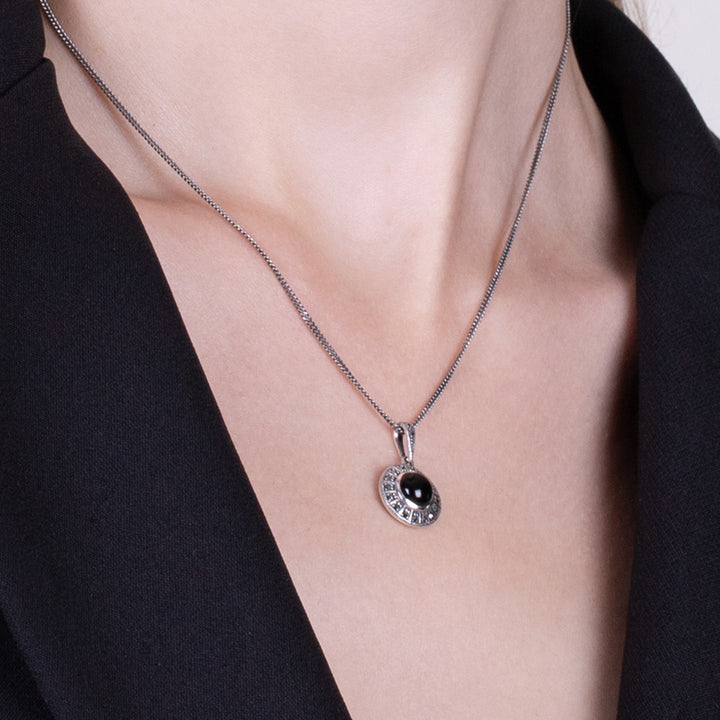Colgante redondo estilo art déco con cabujón de ónix negro y marcasita en plata de ley