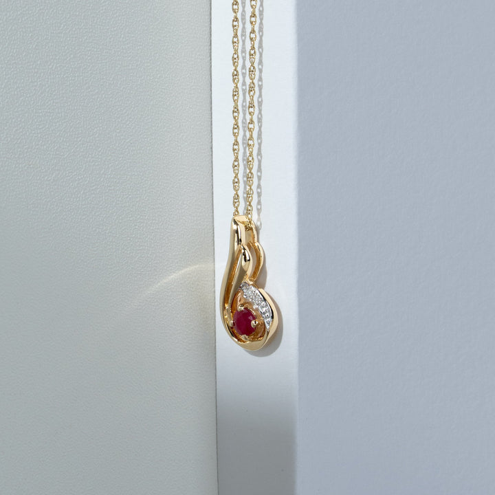 Colgante redondo clásico con gota en espiral de diamantes y rubíes en oro amarillo de 9 quilates