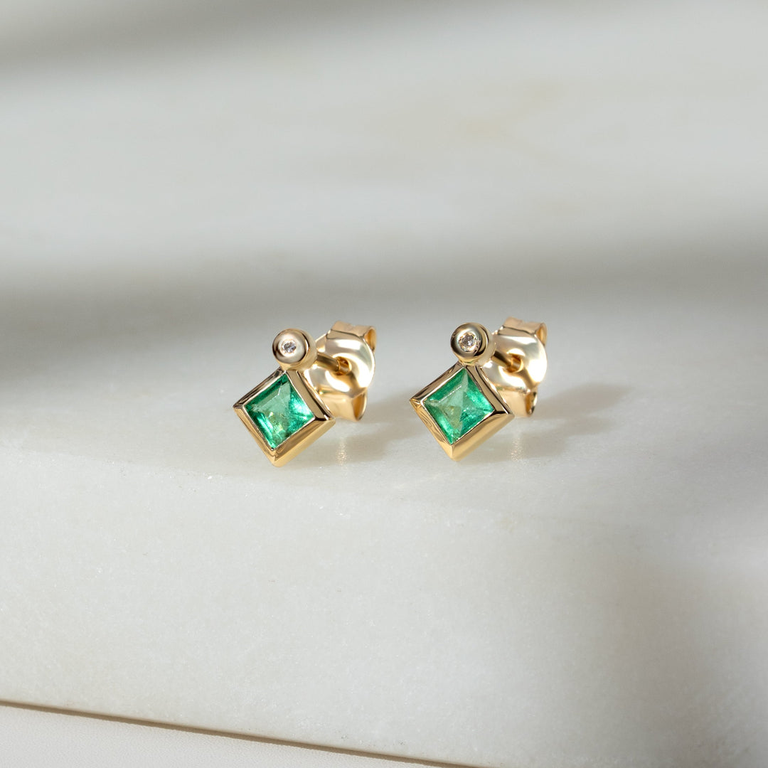 Aretes de botón con esmeralda cuadrada clásica y bisel de diamantes en oro amarillo de 9 quilates
