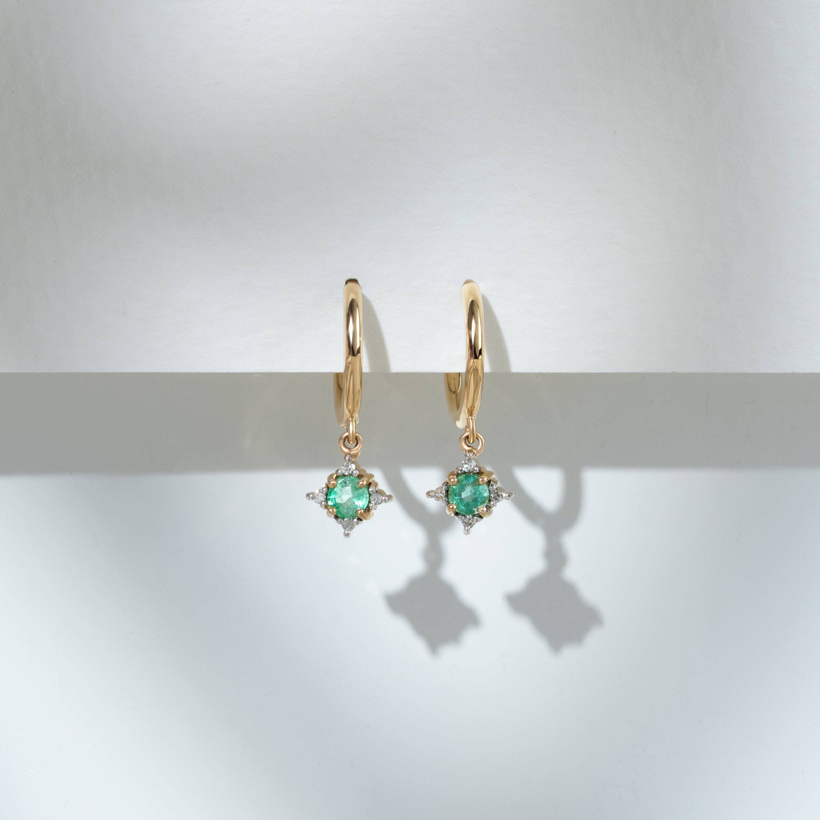 Aretes tipo argolla con diamantes y esmeraldas redondas clásicas en oro amarillo de 9 quilates