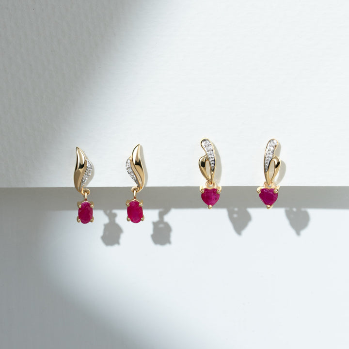 Aretes colgantes torcidos clásicos de diamantes y rubíes ovalados en oro amarillo de 9 quilates