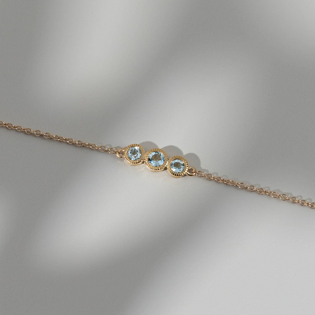 Brazalete redondo clásico con milgrain de tres piedras y aguamarina en oro amarillo de 9 quilates