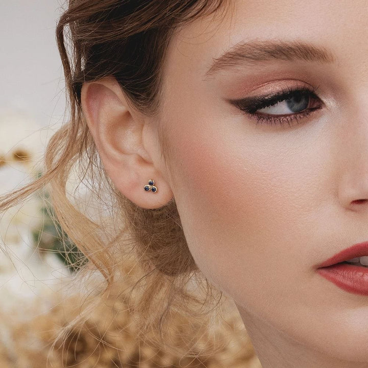 Aretes florales con tres piedras y zafiro en oro amarillo de 9 quilates