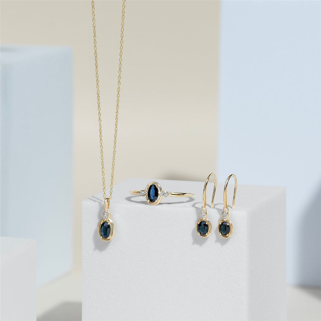 Pendientes colgantes clásicos de zafiro ovalado y diamante redondo en oro amarillo de 9 quilates
