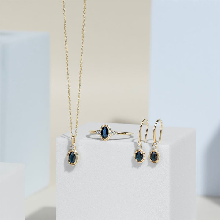 Pendientes colgantes clásicos de zafiro ovalado y diamante redondo en oro amarillo de 9 quilates
